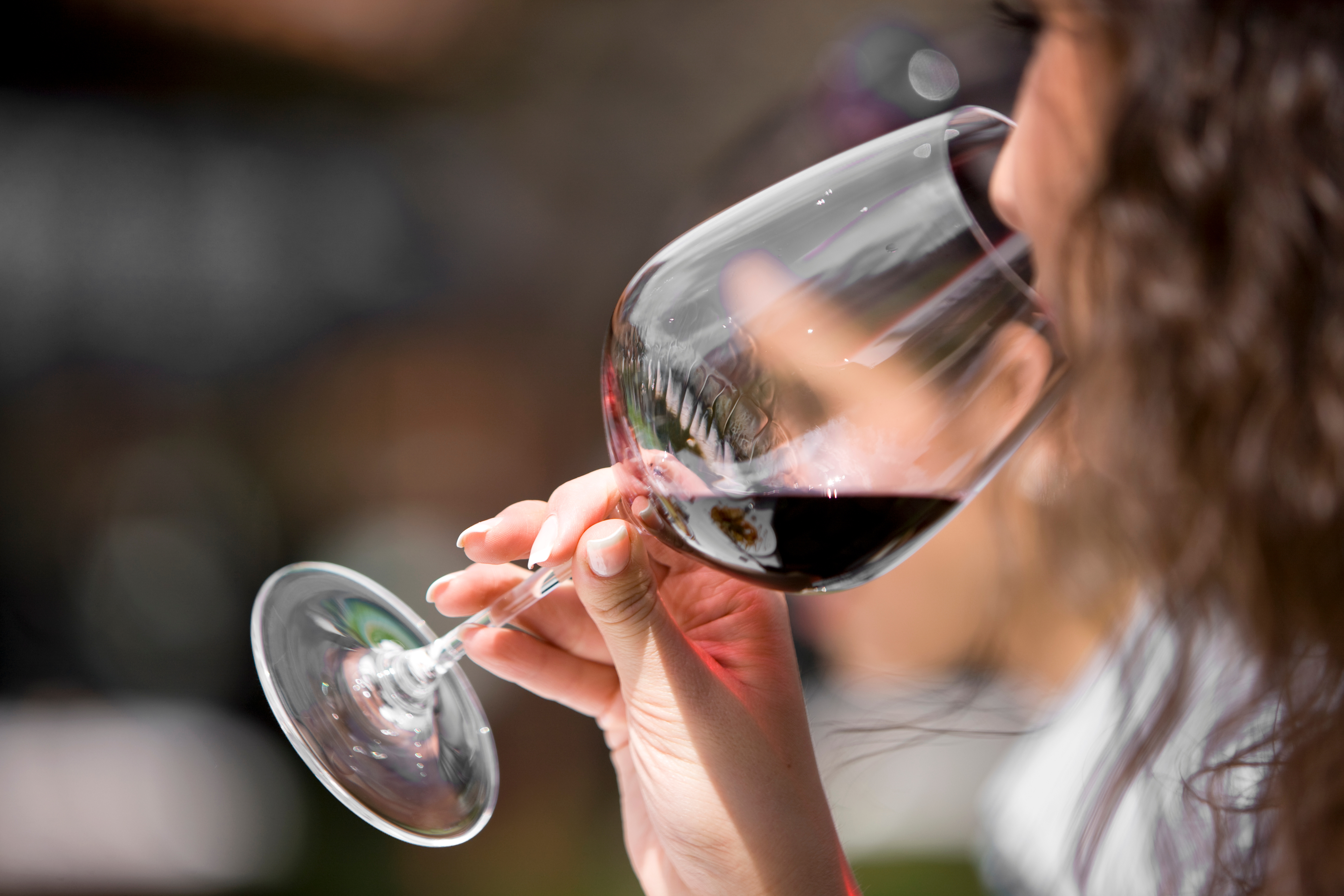 A woman drinking a glass of wine and fighting alcohol addiction