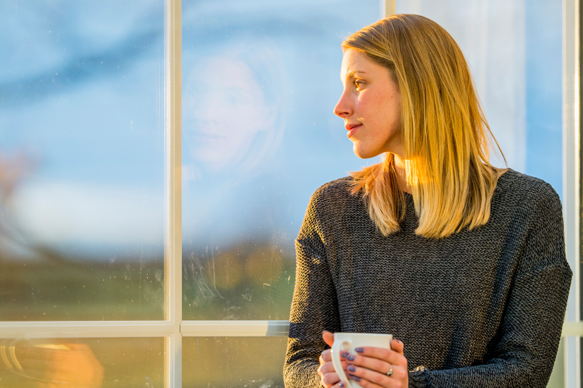 A woman with Schizoaffective Disorder looking out her window.