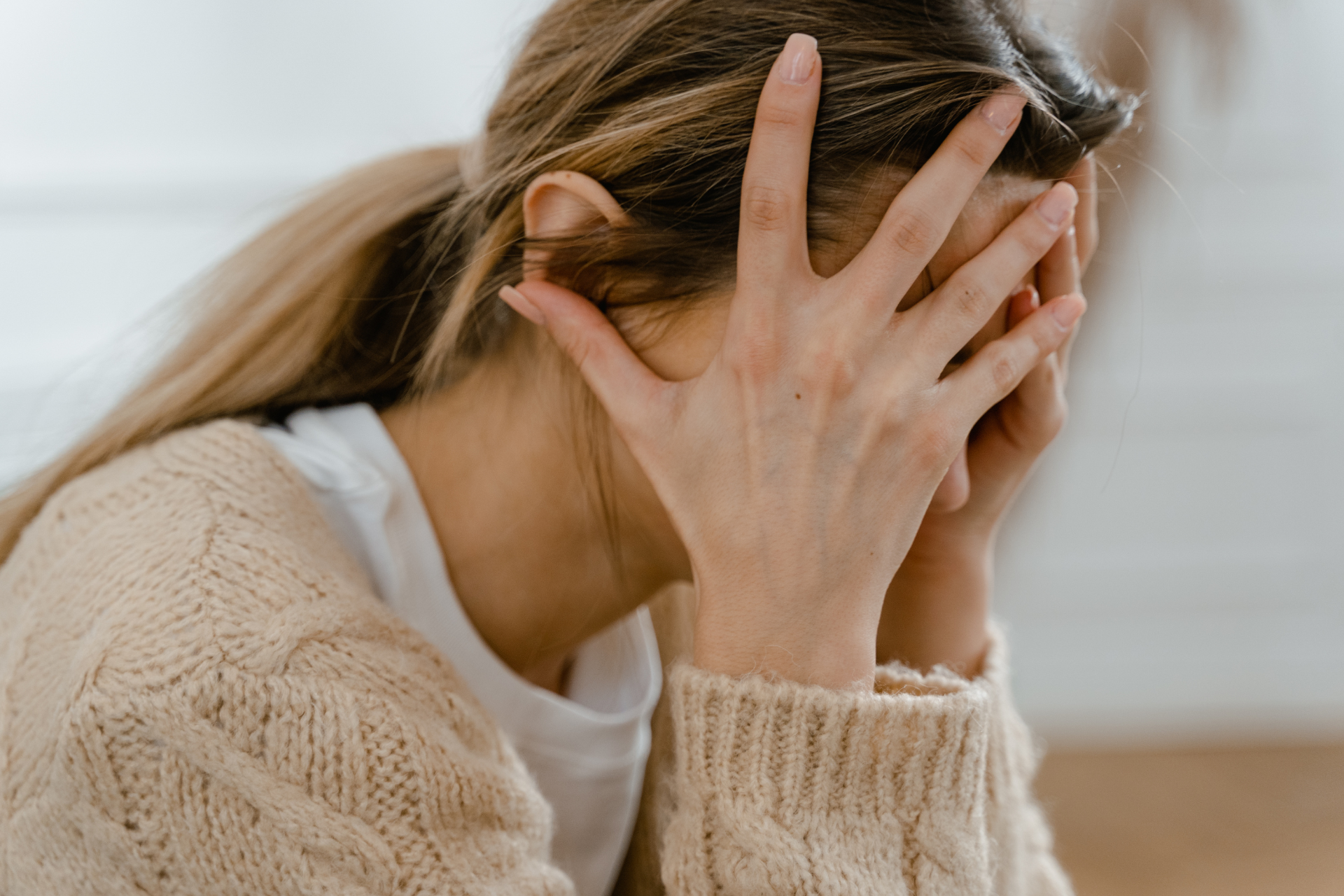 A woman sitting with head in her hands suffering from sedative addiction