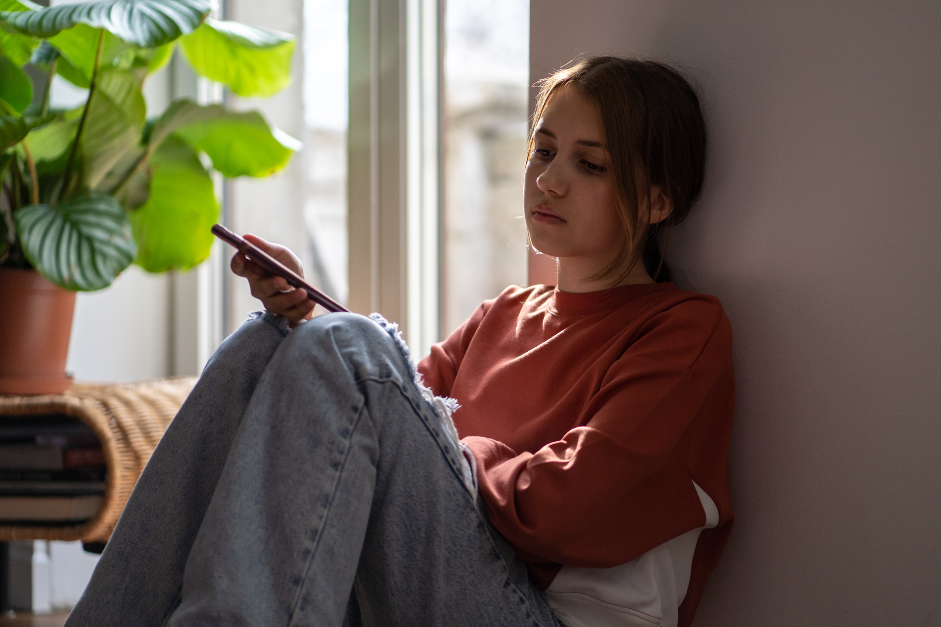 A woman sitting by her window dealing with social anxiety disorder.